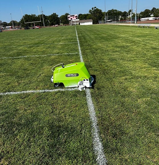 striping machine painting Lebo High School football field close-up