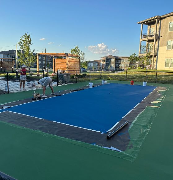 a Property Management Group pickleball court with blue painting before the line markings added