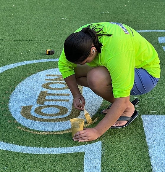 close-up of employee installing new logo for football field