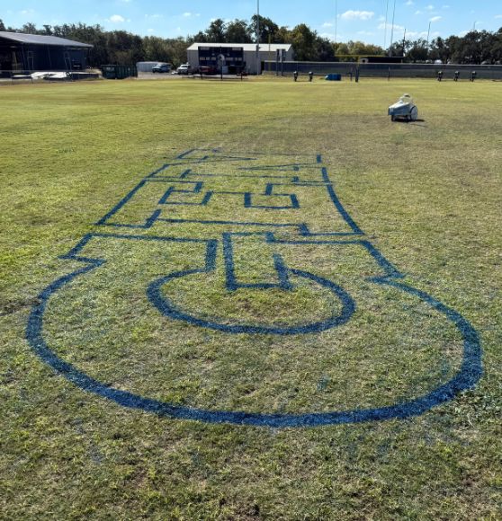 in the process of painting new logo on Geneva School football field
