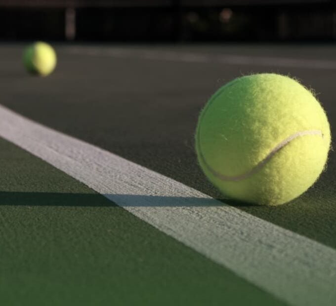 striped tennis court with tennis ball close up