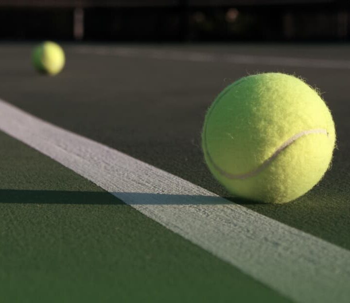 striped tennis court with tennis ball close up