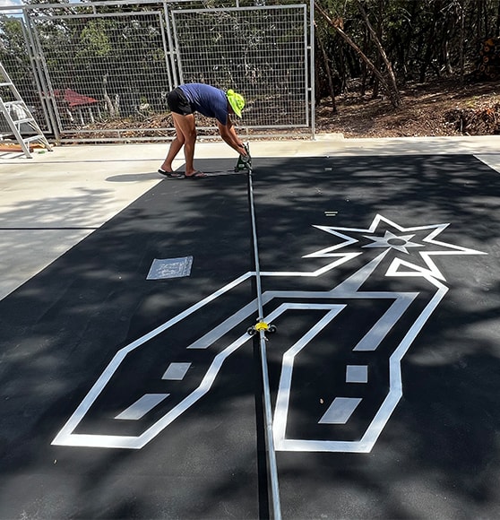 FIELD OPS® painting logo on basketball court for homeowner